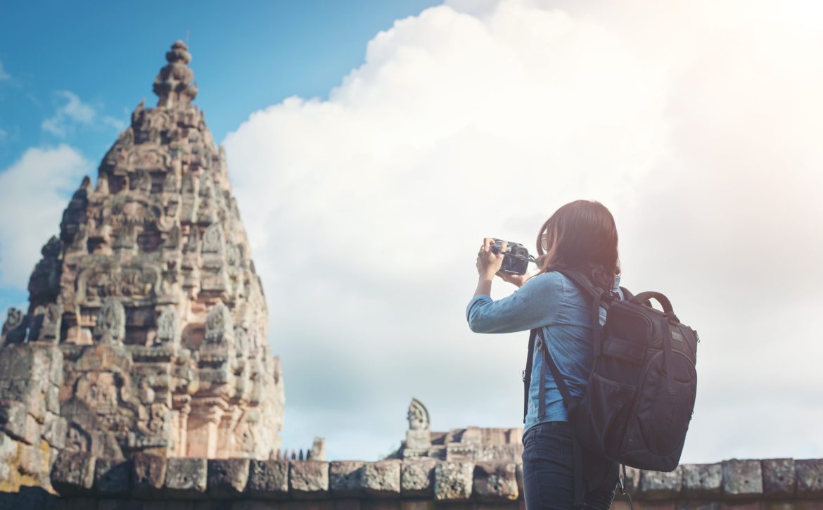 Young attractive woman photographer tourist with backpack coming